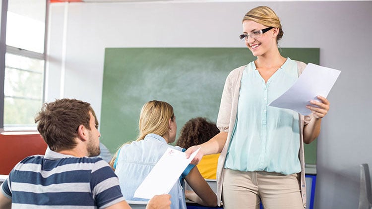 Lehrerin teilt Blätter aus