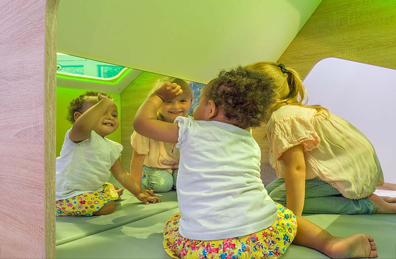 EduCasa Spielhaus Sinne Innenansicht mit Spiegel und grünem Plexiglasdach