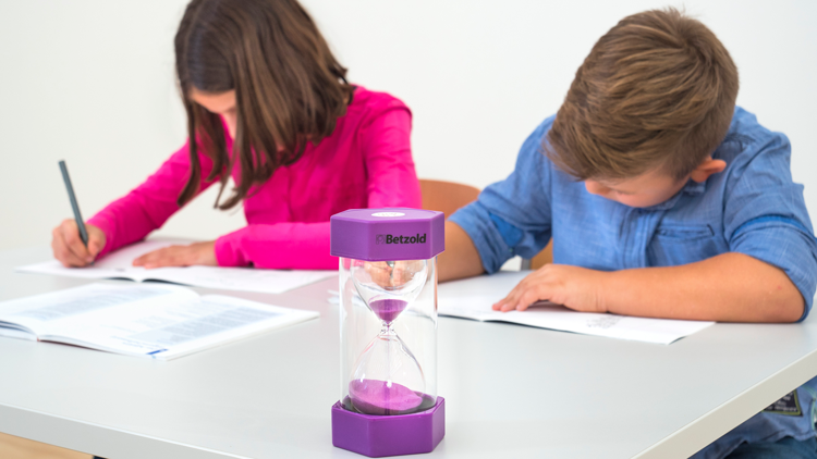 Schreibende Kinder mit Sanduhr