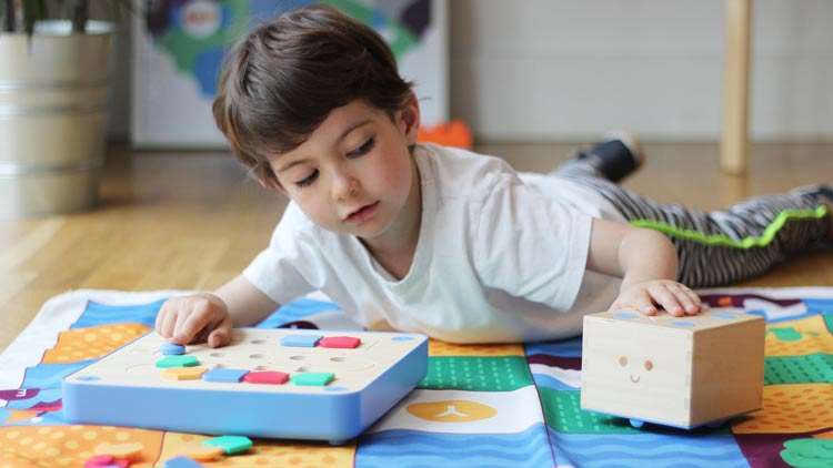 Junge spielt mit dem Cubetto Spiel aus dem Betzold Online-Shop.