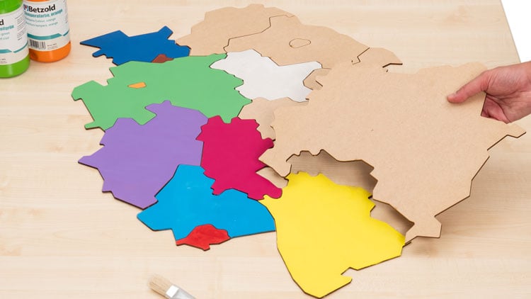 Puzzle, das die deutschen Bundesländer zeigt wird bemalt.