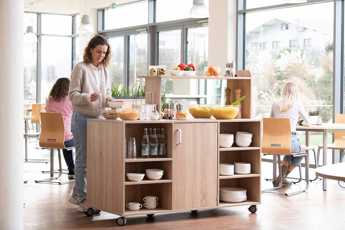 Betzold Buffetwagen beidseitig mit verschiedenem Essen und Geschirr in Mensa Setting