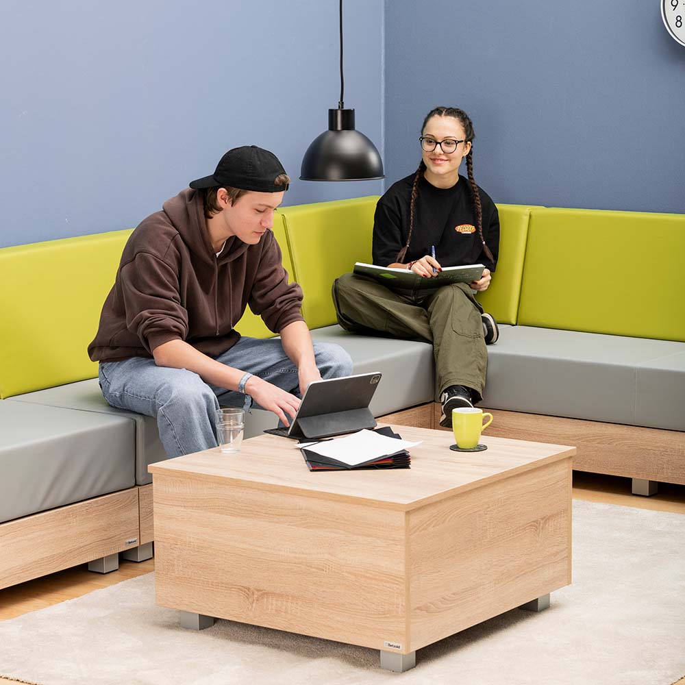 Betzold Couchtisch „Chillo“ mit Chillo Sofa und 2 jungen Leuten