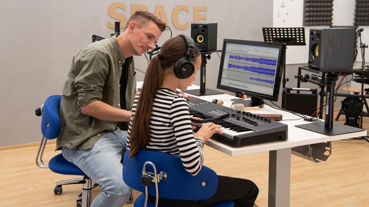 Lehrer unterstützt Schülerin im Makerspace
