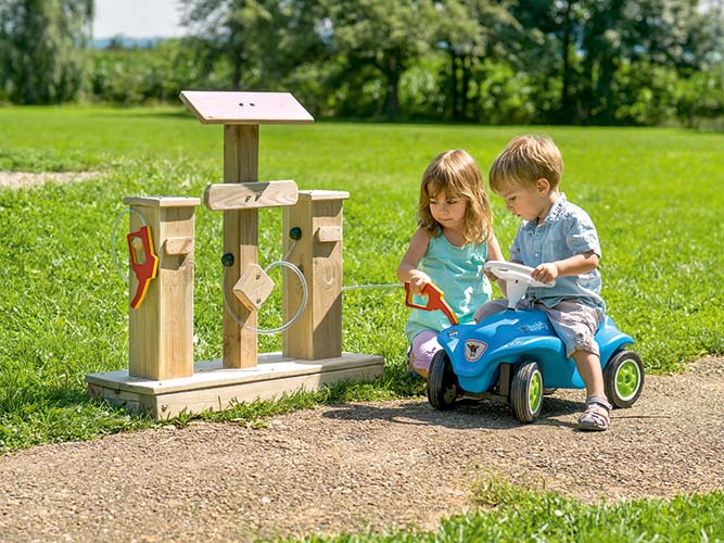 Betzold Tankstelle Betzold Tankstelle im Grünen mit 2 Kindern und einem Bobbycar