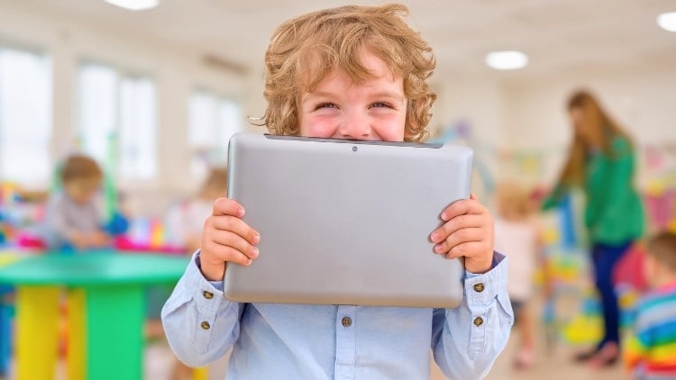 Kind hält sich ein Tablet vor das Gesicht
