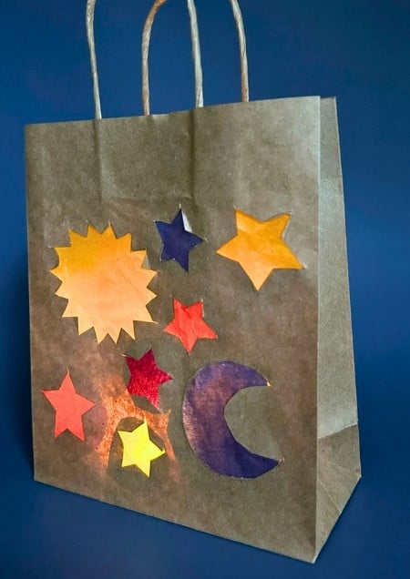 Laterne aus einer Papiertüte mit dem Motiv Sonne, Mond und Sterne