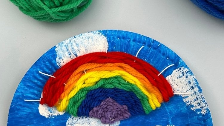Gewebter Regenbogen auf einem Pappteller als Webrahmen.