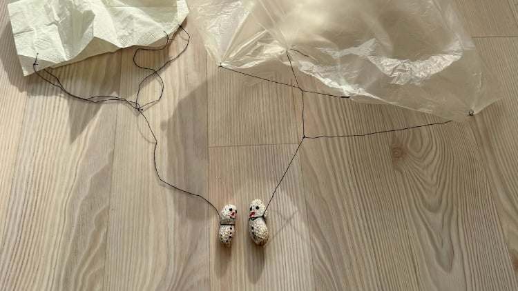 Nuss als Schneemann angemalt und mit Faden an ein Taschentuch gehängt.