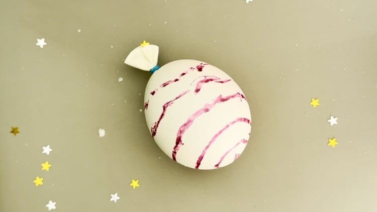 Ein mit Essig und Natron gefüllter Luftballon, der sich aufbläht.