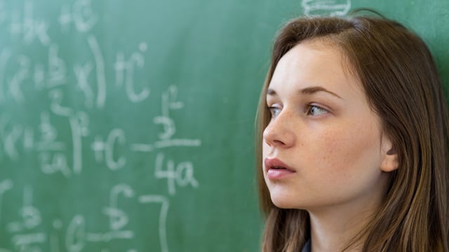 Mädchen vor Tafel mit Mathematikaufschrieben