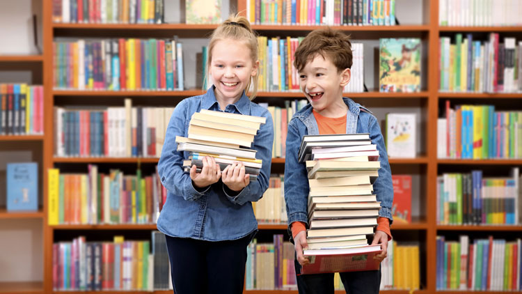 Zwei Kinder stehen vor einem Bücherregal