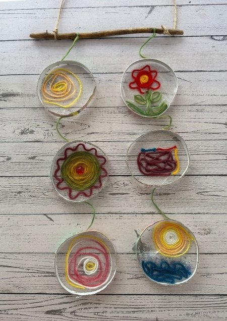 Mobile aus Ringen, in die Fensterfolie und Wolle geklebt wurden.