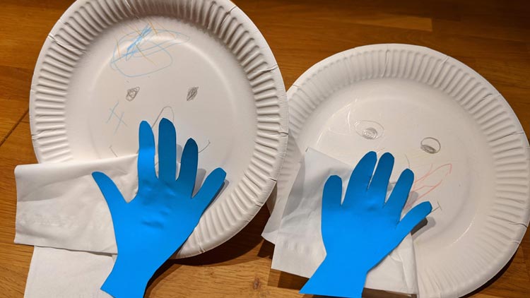 Tonpapier und Taschentuch auf niesenden Pappteller kleben