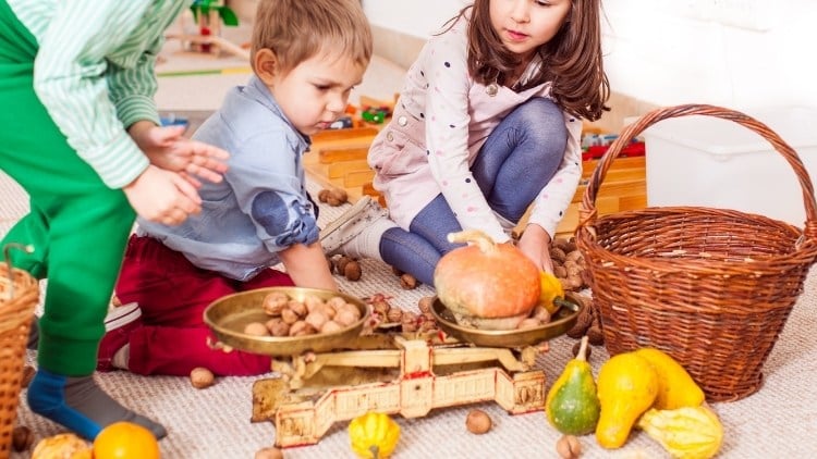 Spielerisch erforschen Kinder das Gewicht von Lebensmitteln mit einer Waage.