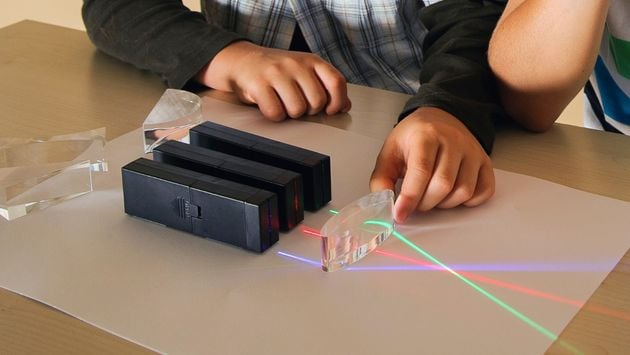 Experiment Optik aufgebautes Experiment mit drei Farbstrahlern, die ein Acryl-Prisma anleuchten