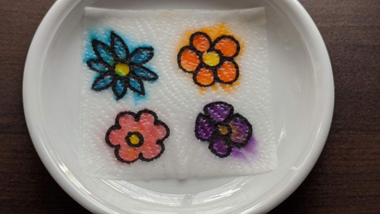 Papierblüten, die in Wasser die Rabe ändern