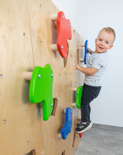 Kleiner Junge an einer Kletterwand