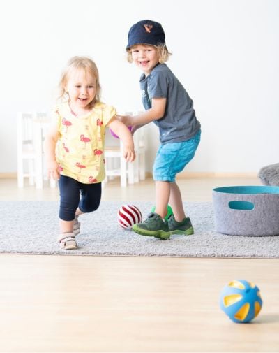Zwei Kinder spielen mit Bällen