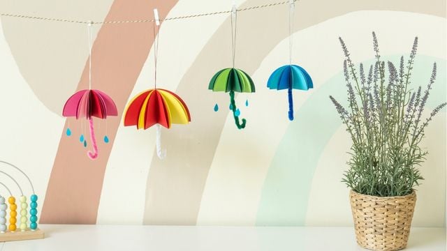 Vier bunte Regenschirme hängen an einer Leine
