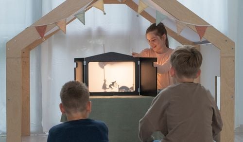 Kombi-Kamishibai-Erzähltheater Kind führt vor Publikum am Kombi-Theater ein Schattenspiel auf