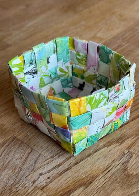 Auch einen Korb können Kinder aus Geschenkpapierresten flechten.
