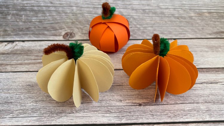 Mit wenig Material Kürbisse aus Tonpapier und Pfeifenputzern basteln.