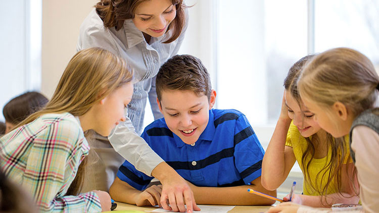 Lehrerin hilft Schülergruppe