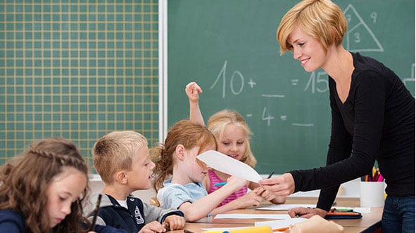 Lehrerin teilt Arbeiten aus