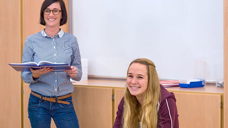 Mädchen Lehrerin lachend im Klassenzimmer