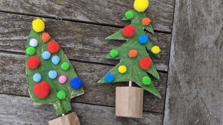 Weihnachtsbäume aus Pappe gebastelt und mit Pompons beklebt.