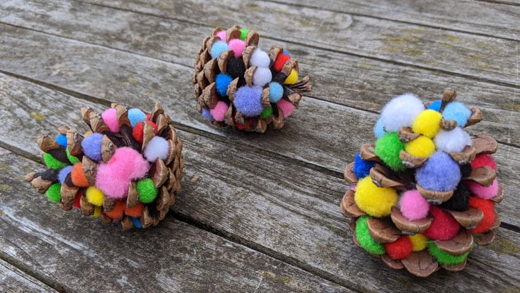Christbaumschmuck aus Kiefernzapfen und Pompons aus dem Betzold Online-Shop.