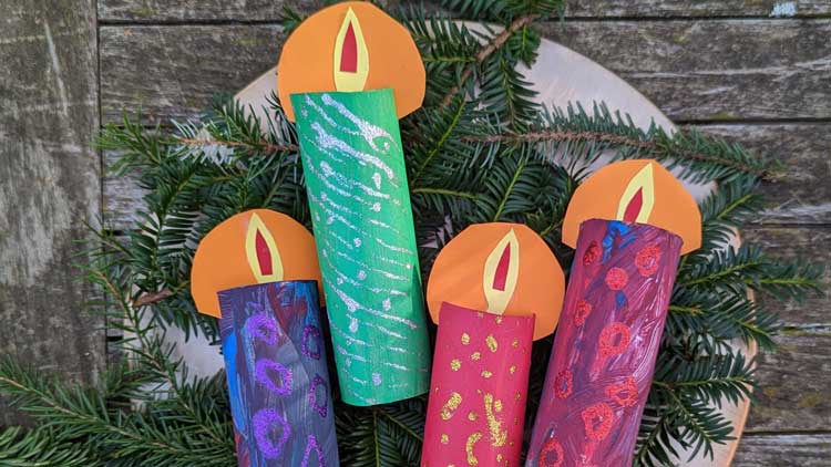Aus einer Papprolle entstehen mit Fingerfarbe und Tonpapier Adventskerzen.