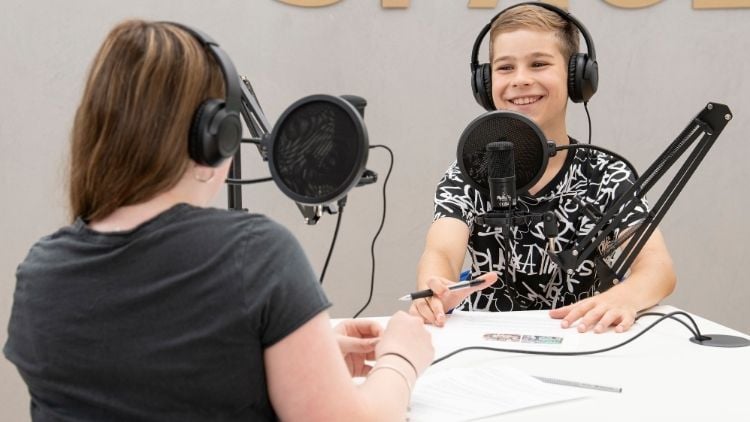 Zwei Kinder nehmen einen Podcast auf.