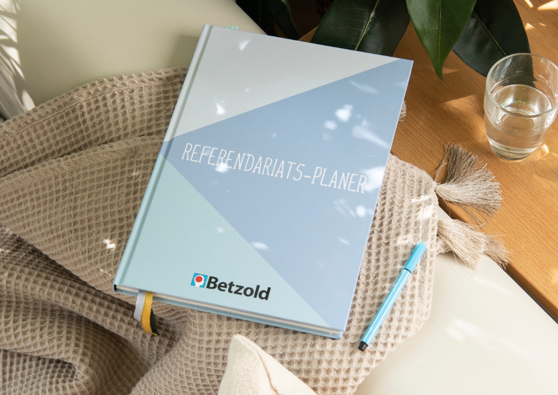 Referendariatsplaner mit Cover aus diversen Blautönen auf einem Sofa liegend