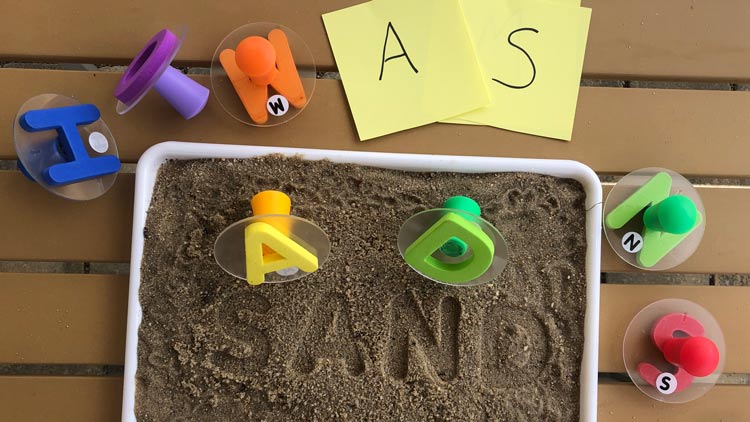 Aktionstablett mit Sand und Buchstabenstempeln aus dem Betzold Online-Shop.