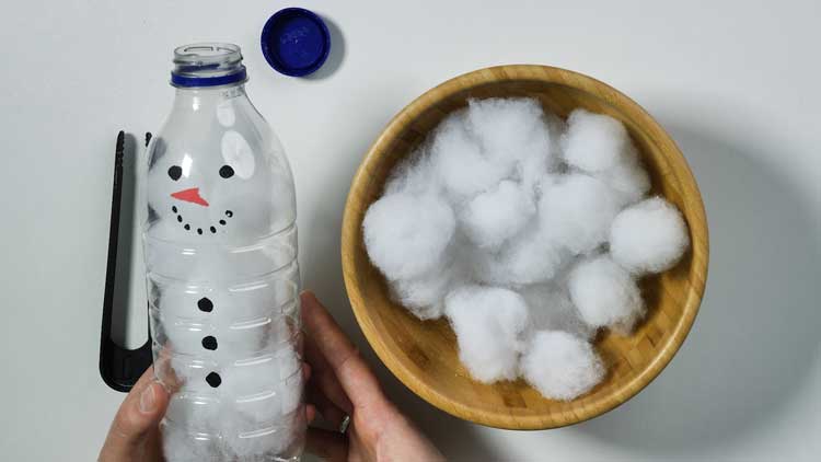 Mit Watte und einer Flasche mit großer Öffnung lässt sich schnell ein Schneemann gestalten.