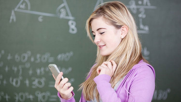 Schülerin schaut auf Handy