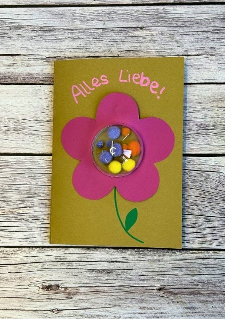 Grußkarte mit einer Blume auf der Front, die mit einer gefüllten Acrylglaskugel verziert ist.