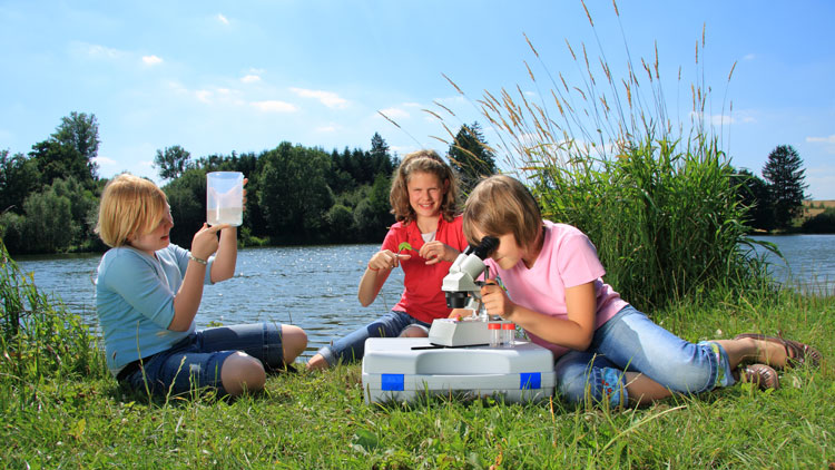 Kinder machen Experimente mit dem Mikroskop
