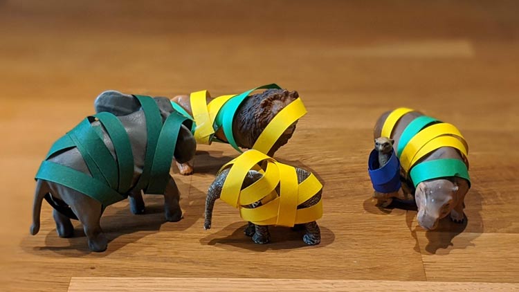 Tierfiguren aus dem Betzold Online-Shop werden mit Papier umwickelt.