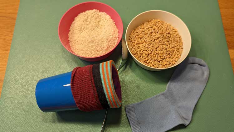 Um Socken mit Reis oder Dinkel zu füllen und in ein Wärmekissen zu verwandeln, kann die Socke über einen Becher gespannt werden, um das Einfüllen zu erleichtern.