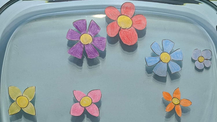Papierblüten schwimmen in Wasserschüssel