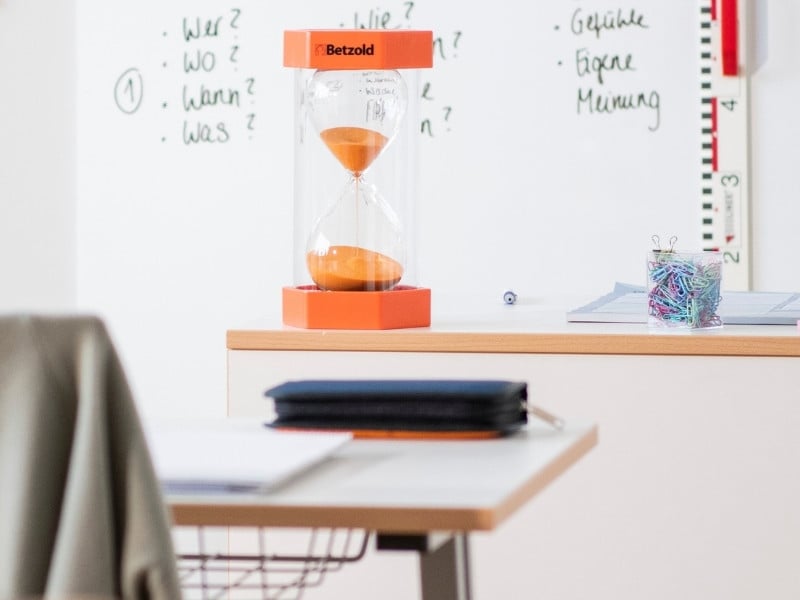 Konzentration Sanduhr große orangene Sanduhr steht auf dem Lehrerpult