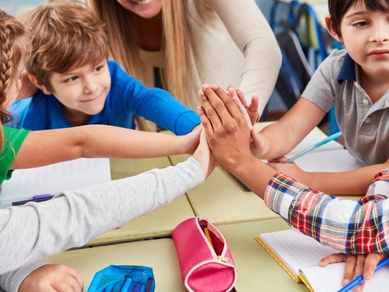 Mehere Kinder legen ihre Hände zusammen