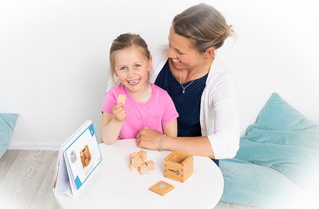 Kind stapelt mit Mama Holzklötze