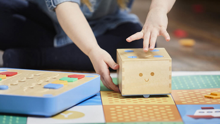 Kind spielt mit programmierbarem Roboter