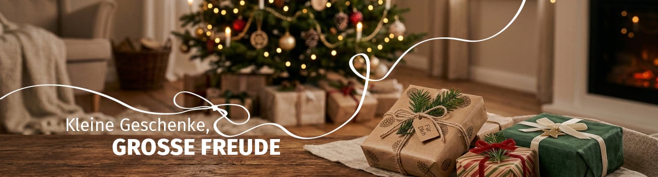 Geschenke Liebevoll verpackte Weihnachtsgeschenke mit Schleifen und Tannenzweigen auf einem Holztisch vor einem geschmückten Weihnachtsbaum.