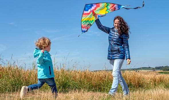 Kind und Frau beim Drachensteigen