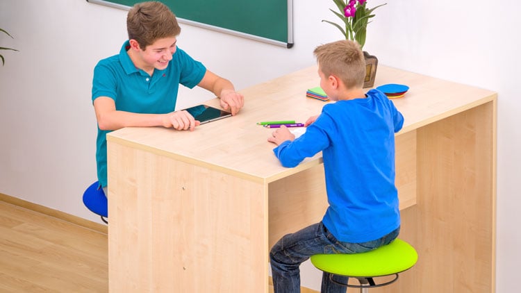Kinder mit Tablet am Schultisch